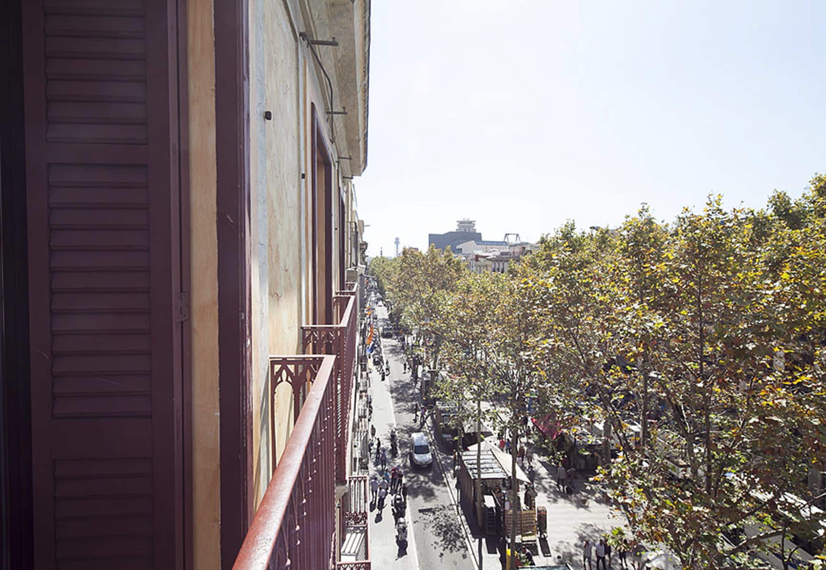 A street view with buildings, trees, and a clear sky.
