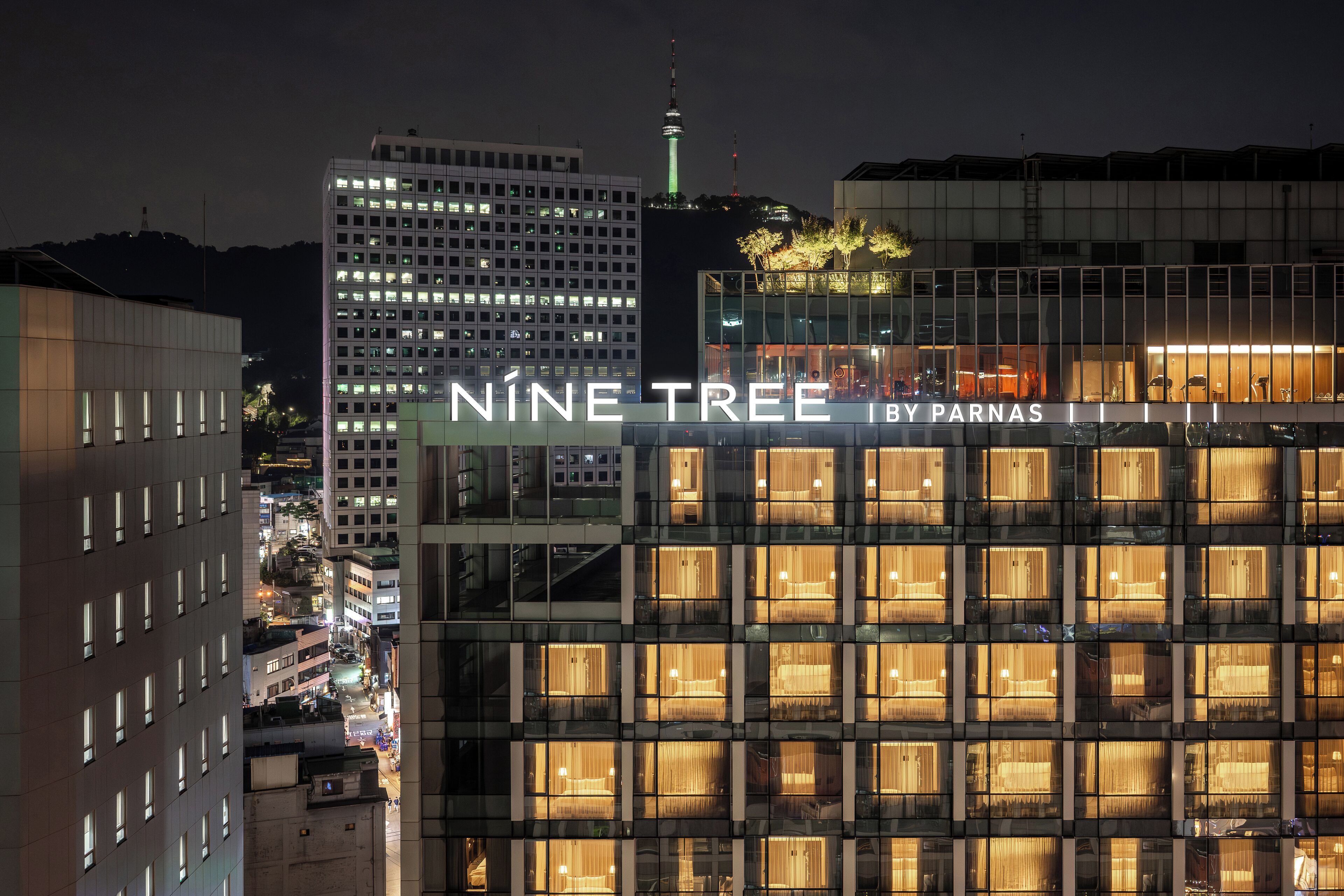 Um edifício moderno com uma placa que diz 'Nineteen Tree by Parnas'.