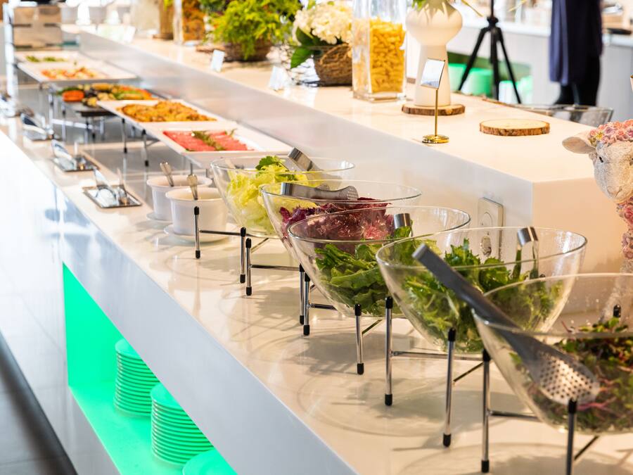 A buffet with various food options and a decorative sheep figure.