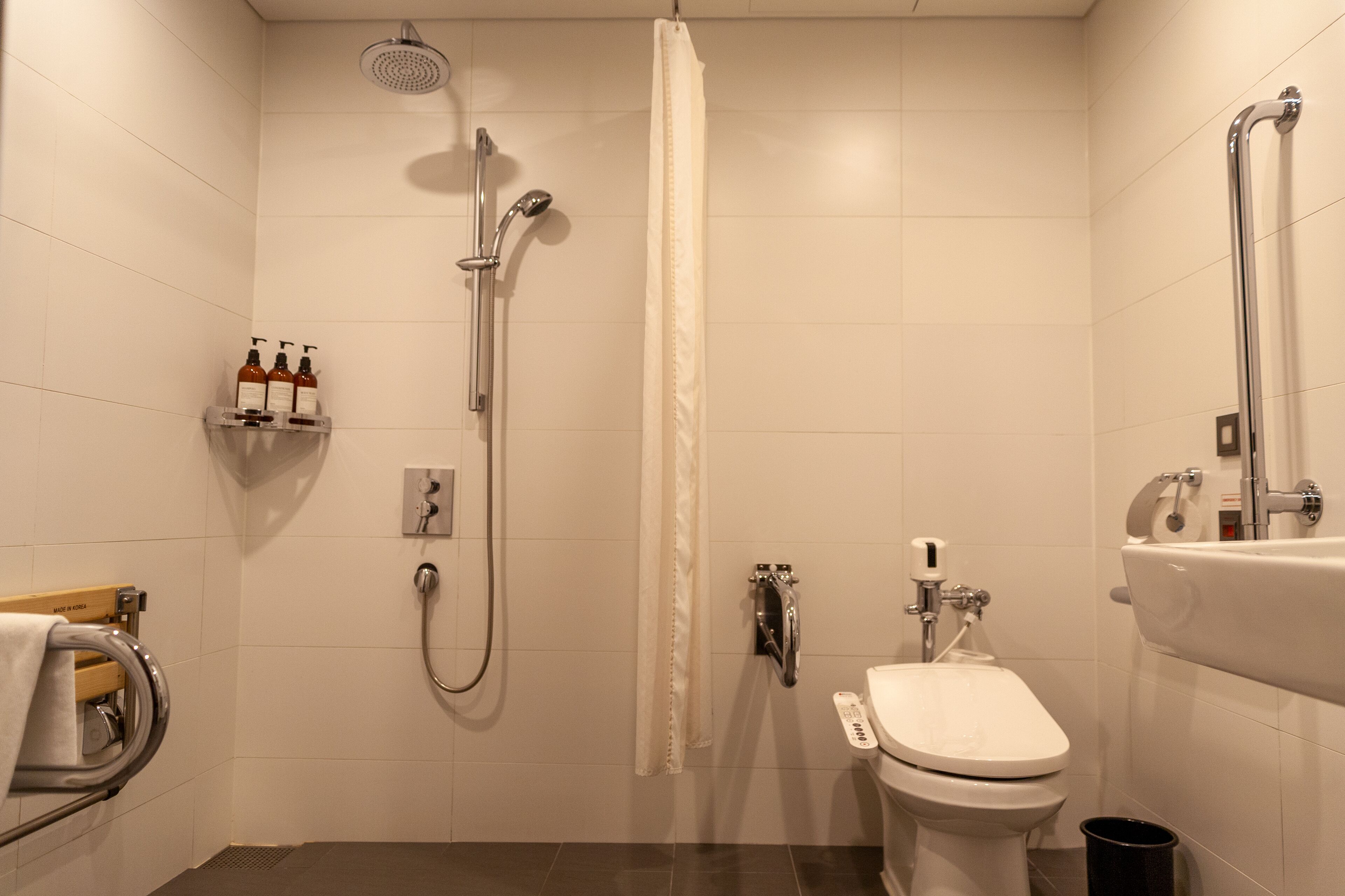 A modern bathroom with a shower, toilet, and sink.