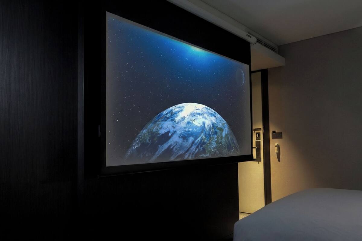 A television mounted on a wall displaying a space scene.