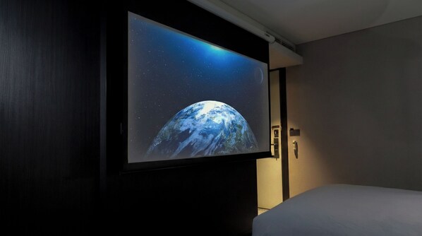 Un televisor montado en la pared mostrando una escena espacial.