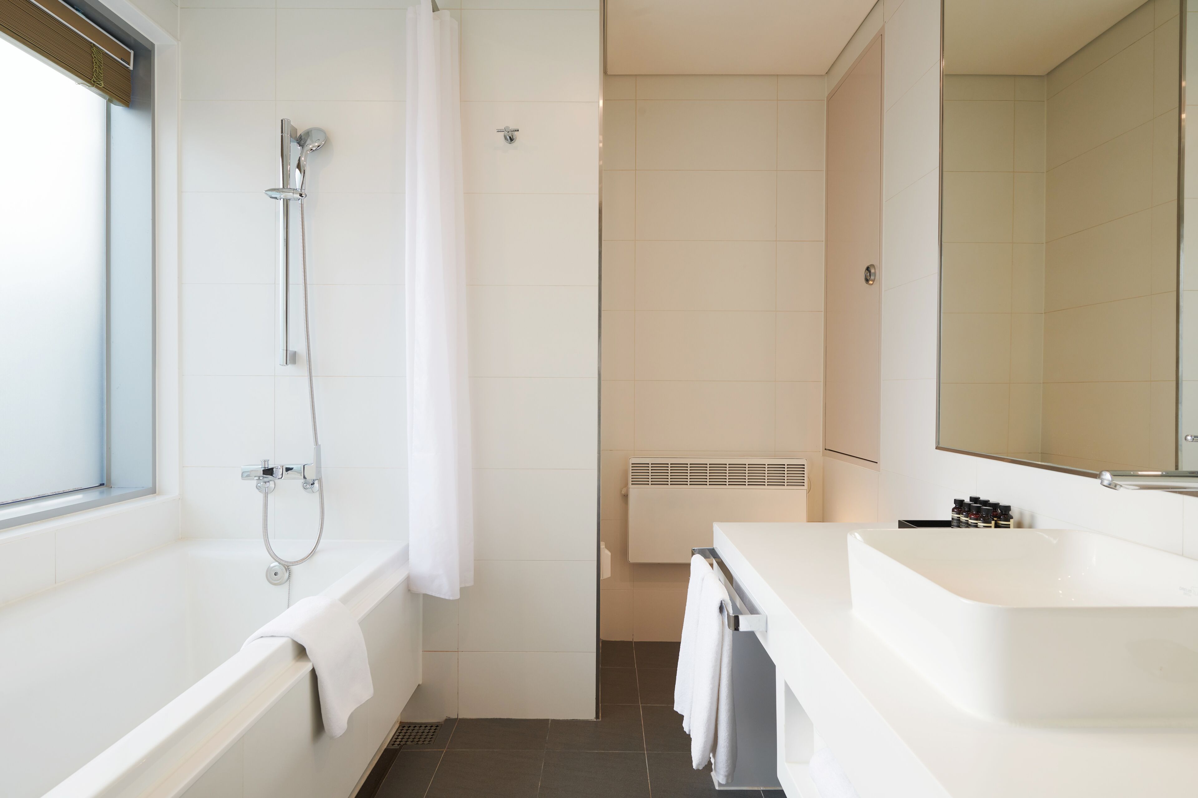 A modern bathroom with a bathtub, a shower, and a sink.