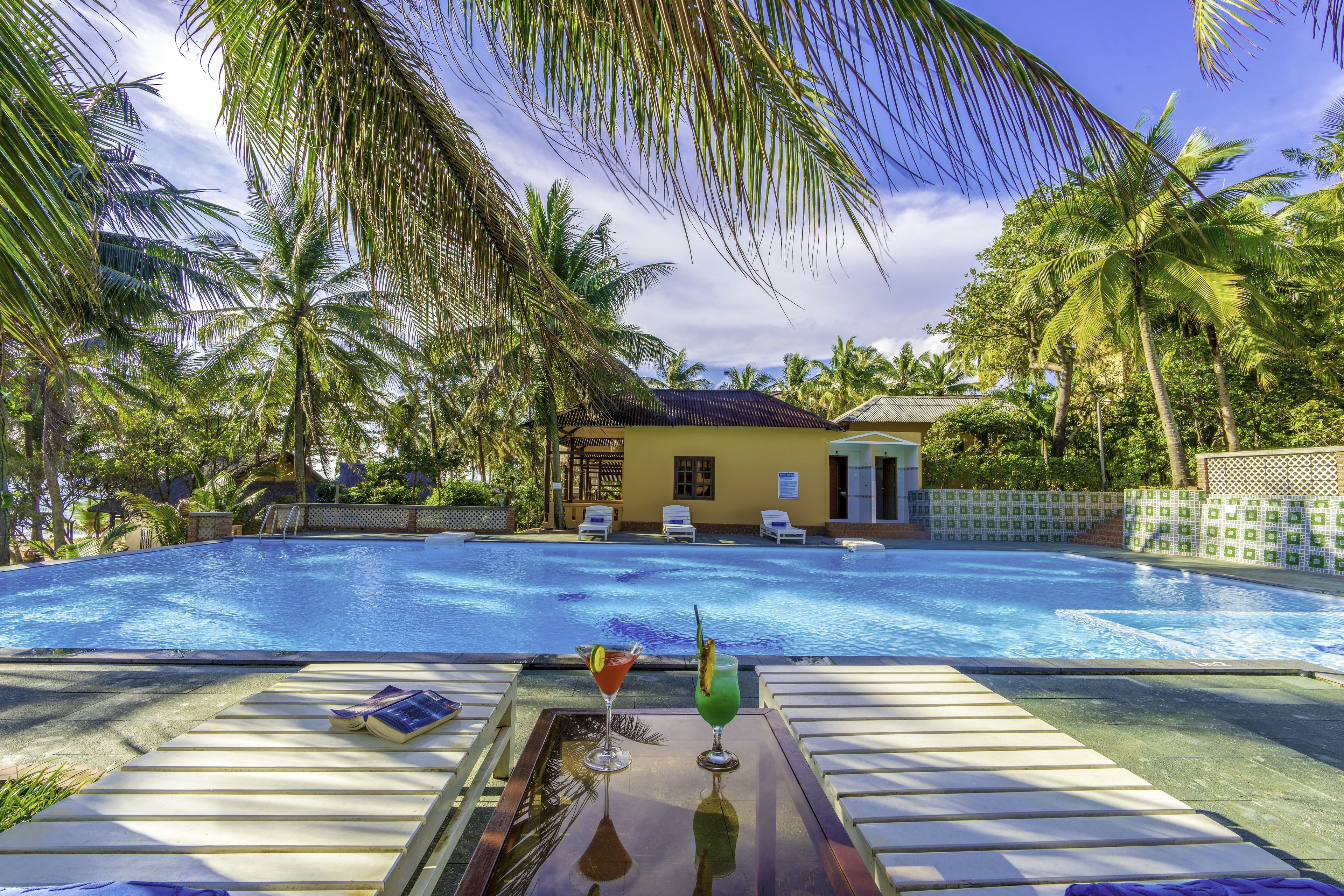 Una piscina al aire libre, sombrillas, tumbonas
