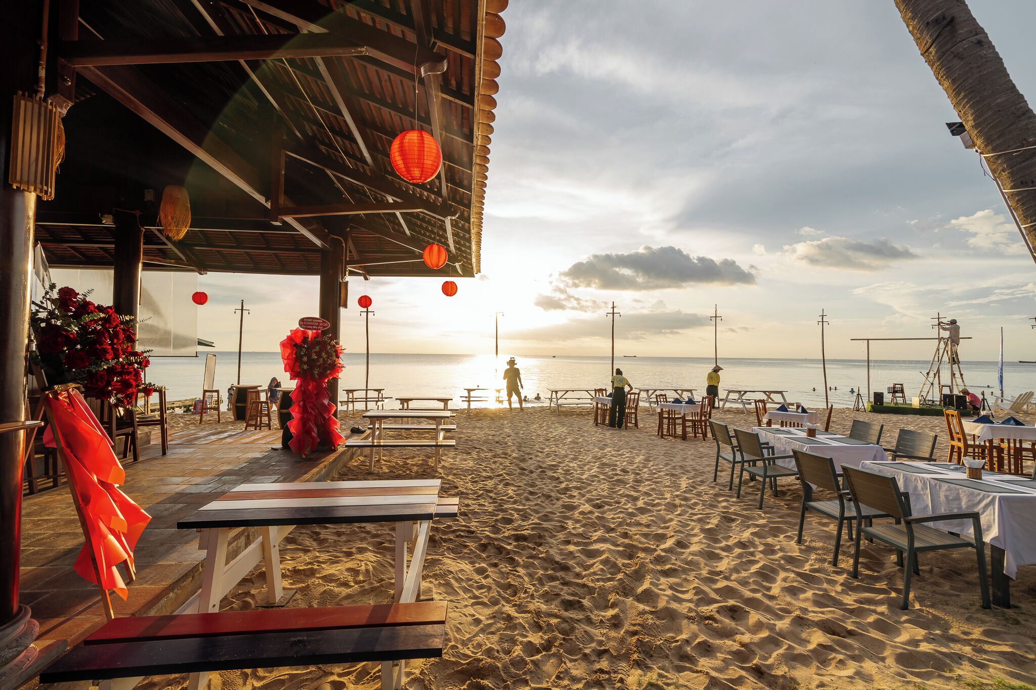 Un restaurant situé en bord de mer, avec une terrasse, des tables et des chaises, offrant une vue sur l’océan.