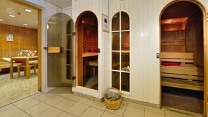 Una sala de sauna con bancos de madera y una pequeña mesa con un vaso de agua.