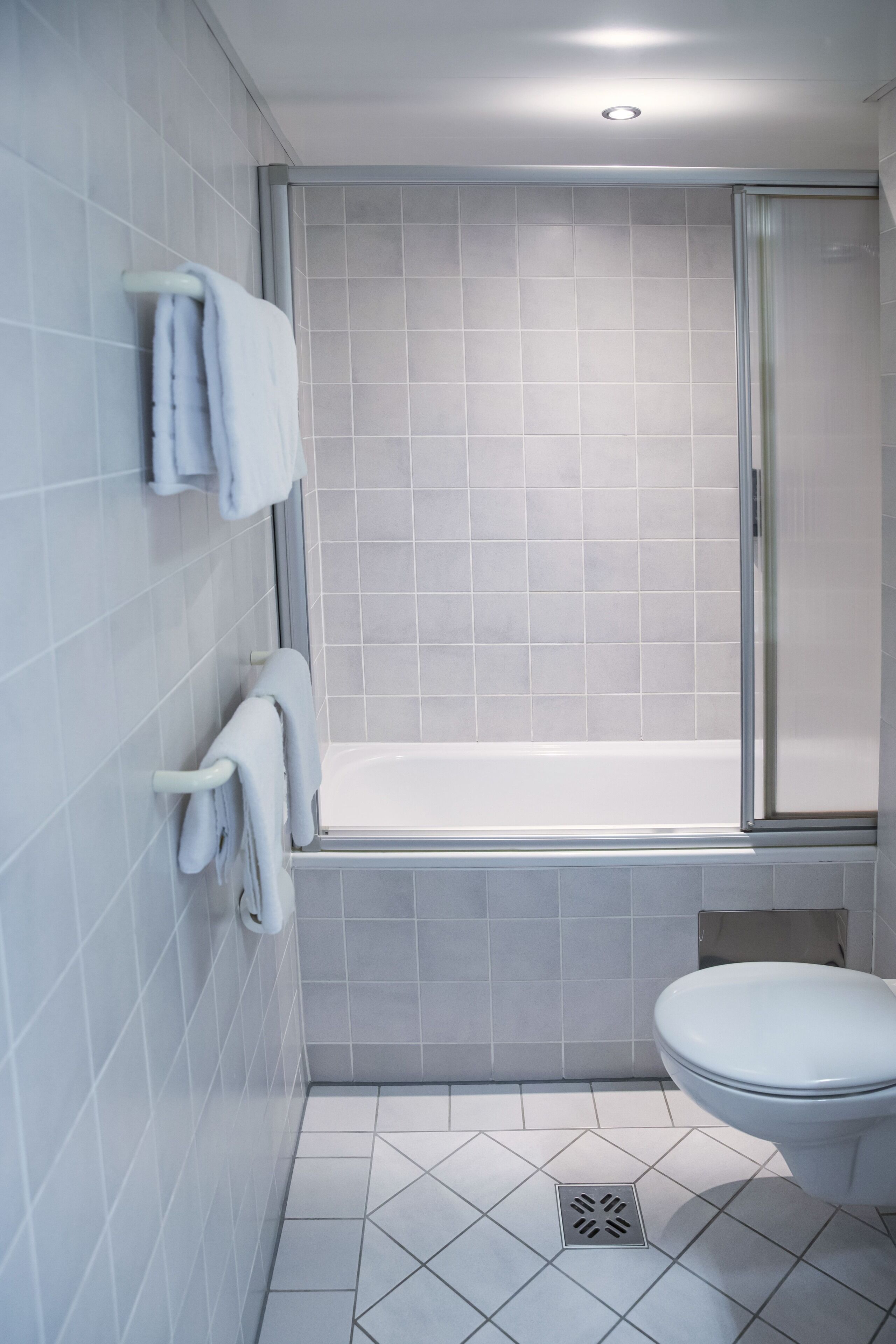 A bathroom with a bathtub, toilet, and a shower area.