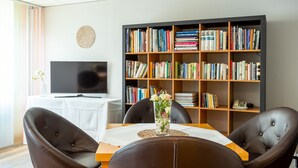 Una sala de estar moderna con una estantería, un televisor de pantalla plana y sillones de cuero.
