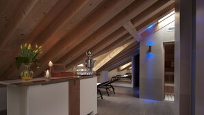Une cuisine moderne avec un plafond en bois, un îlot central agrémenté d’un vase de fleurs et un coin repas avec des bancs.