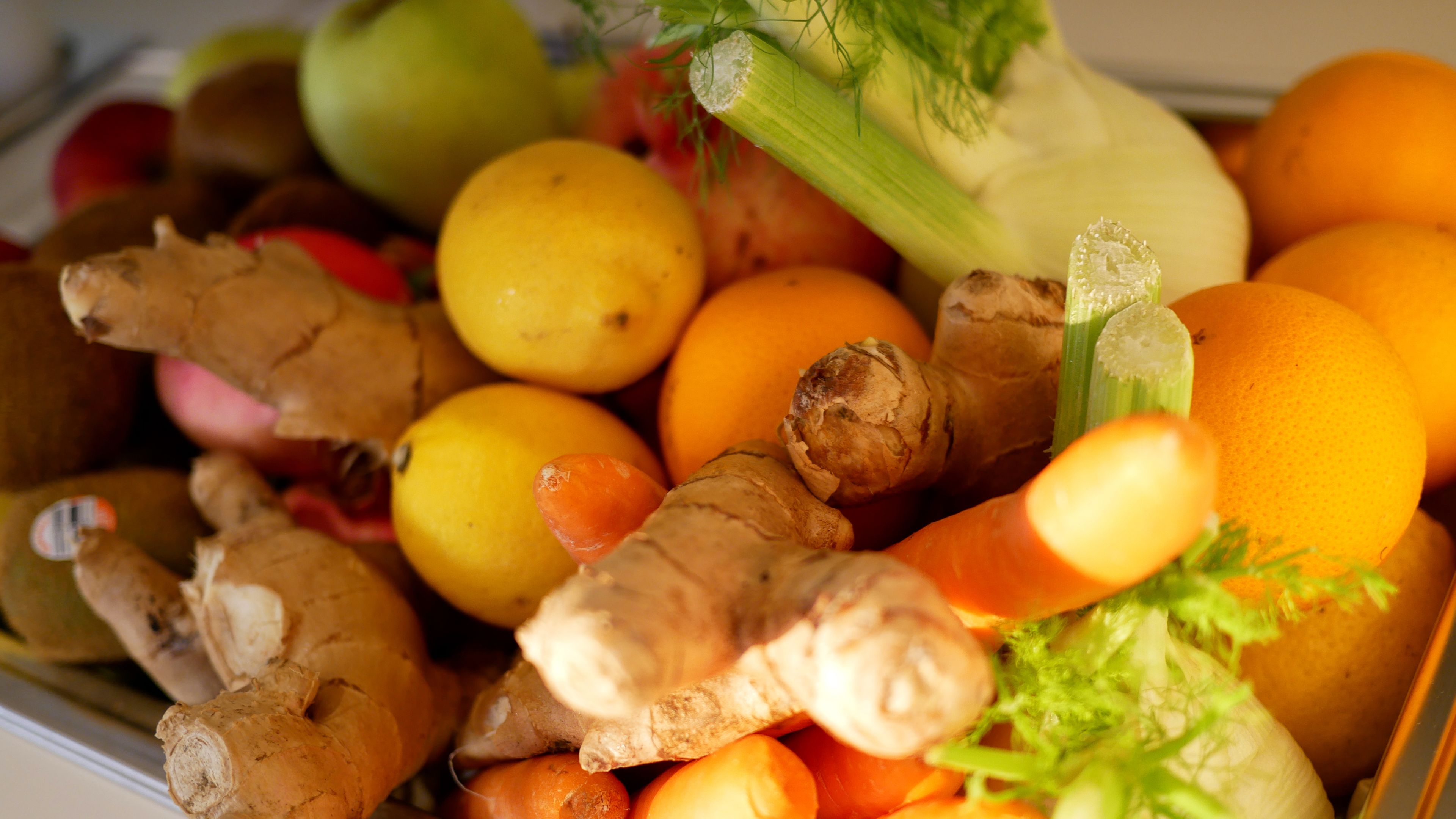 A variety of fresh fruits and vegetables including oranges, lemons, and ginger.