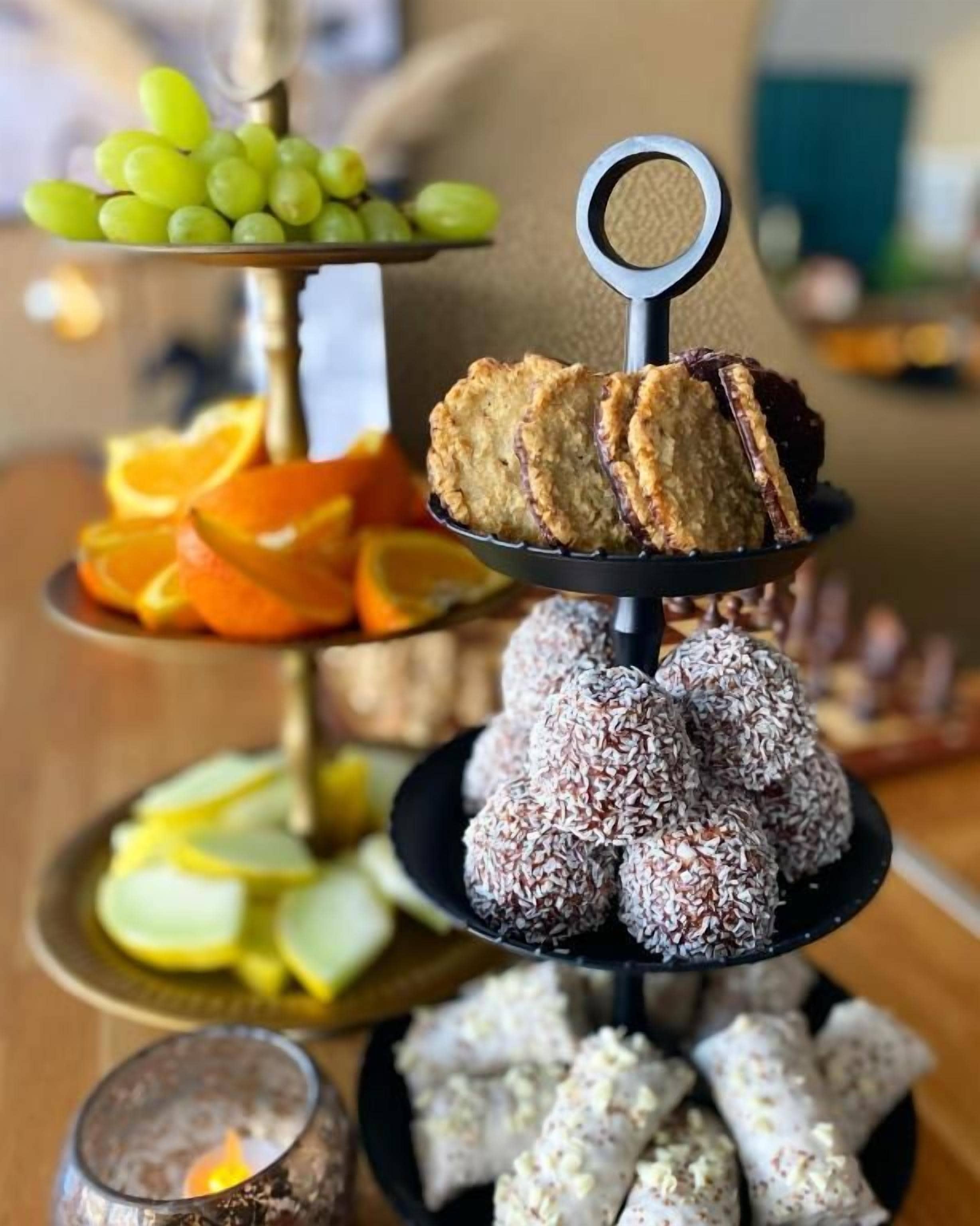 Un soporte escalonado para postres con diversos dulces y frutas.