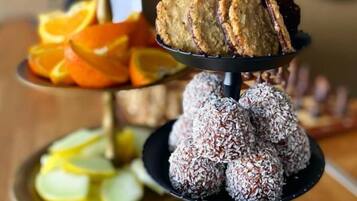 Un soporte escalonado para postres con diversos dulces y frutas.