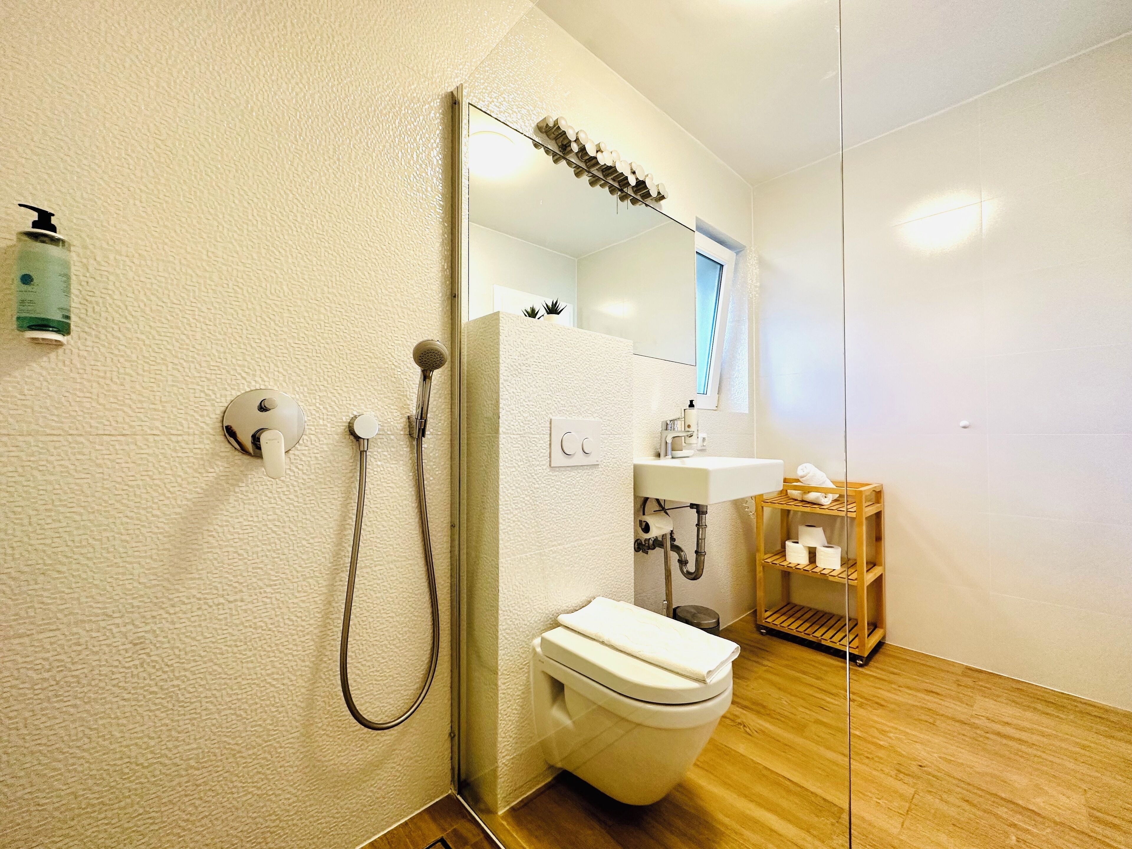 Et moderne badeværelse med bruser, toilet og vask.