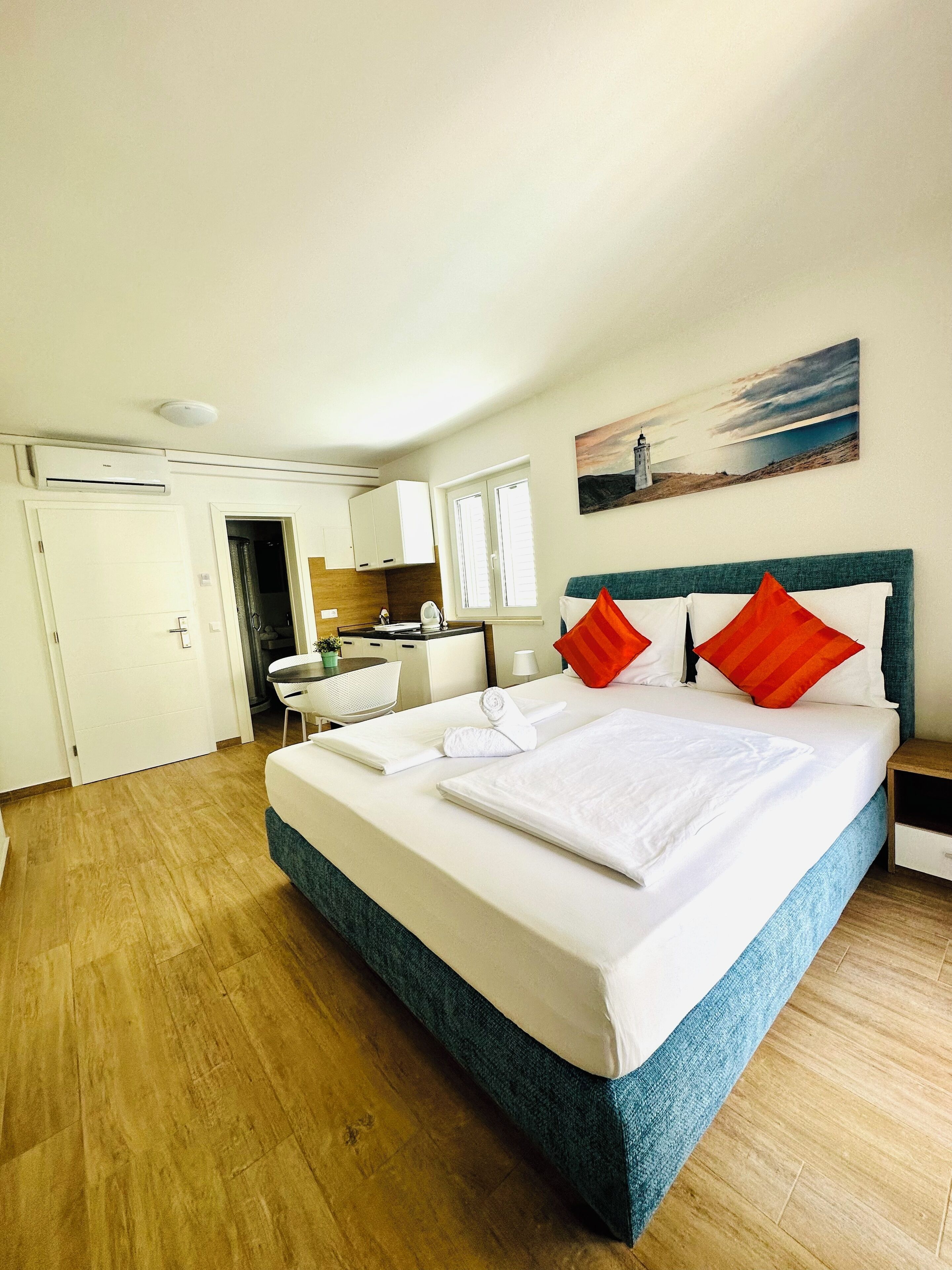 Une chambre d’hôtel avec un lit, un bureau, une chaise et un tableau au mur.