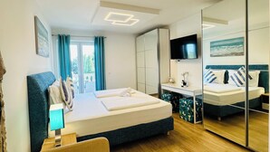 Una habitación de hotel moderna con una cama grande, un sofá, un televisor y un espejo.