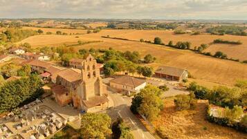 Vista aérea de un pueblo con una iglesia destacada, un cementerio y campos circundantes.