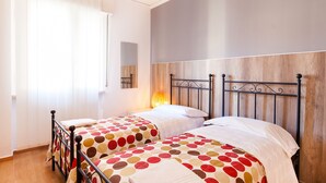 A double room with two beds, each with a polka dot bedspread, a bedside table, and a lamp. - B&B Maricla (Verona)