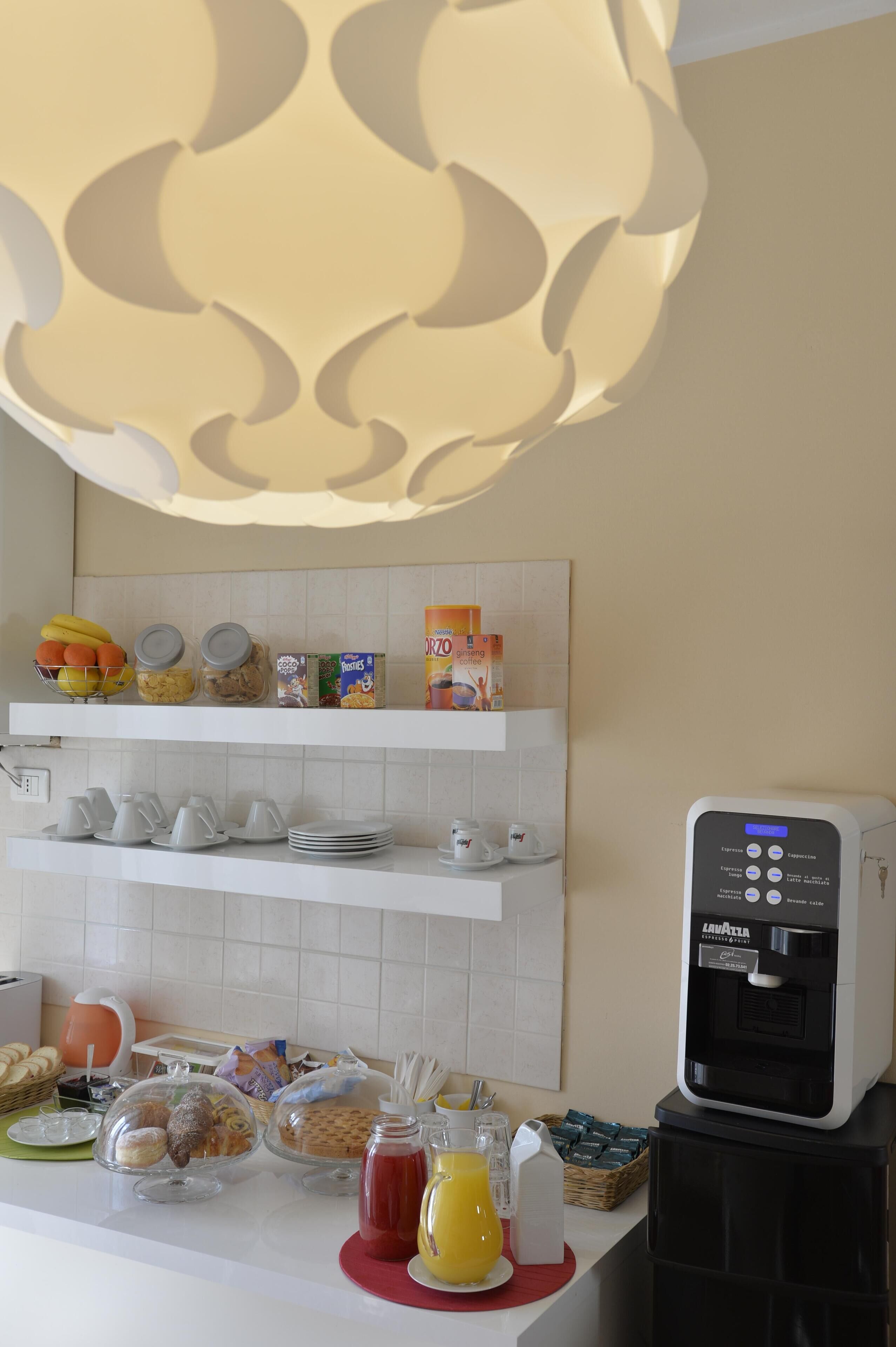 A breakfast bar with various food items, a coffee machine, and a water dispenser.