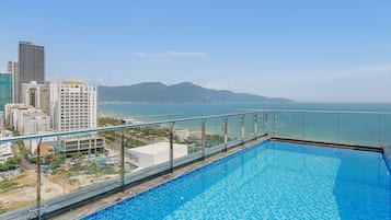 Una piscina al aire libre, sillones reclinables de piscina