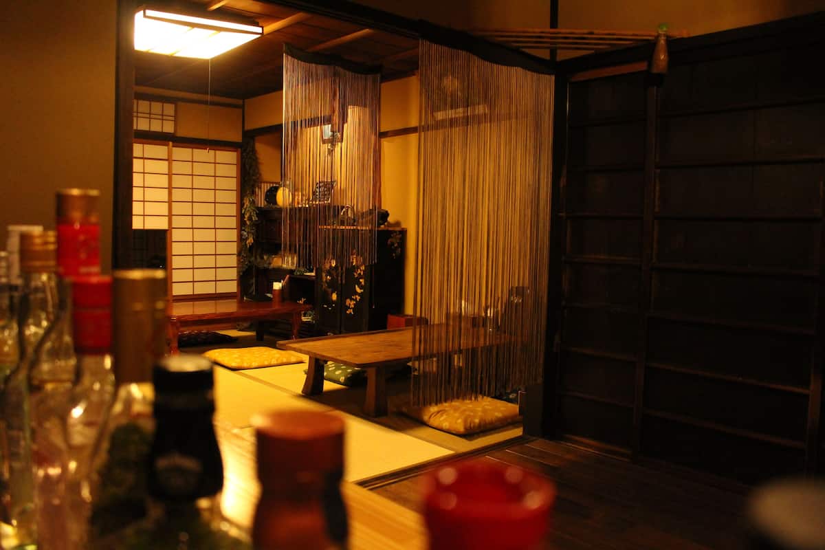 A traditional Japanese room with tatami flooring, a low wooden table, and shoji screens.