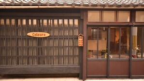 Un edificio tradicional japonés con una valla de madera y un letrero que dice "Colours".
