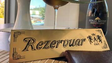 A bottle of Colle Secco wine, a glass of red wine, and a box labeled "Rezerwuar" on a table.