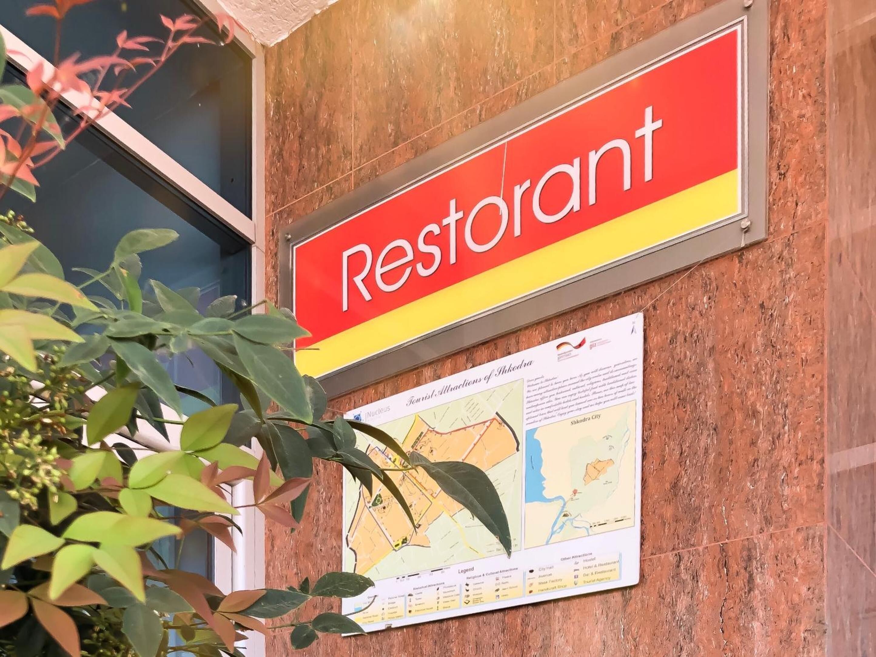 A sign for a restaurant with a map and informational poster below it.