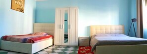A bedroom with two beds, a wardrobe, and a bedside lamp. - Nightstars B&B (Mestre)