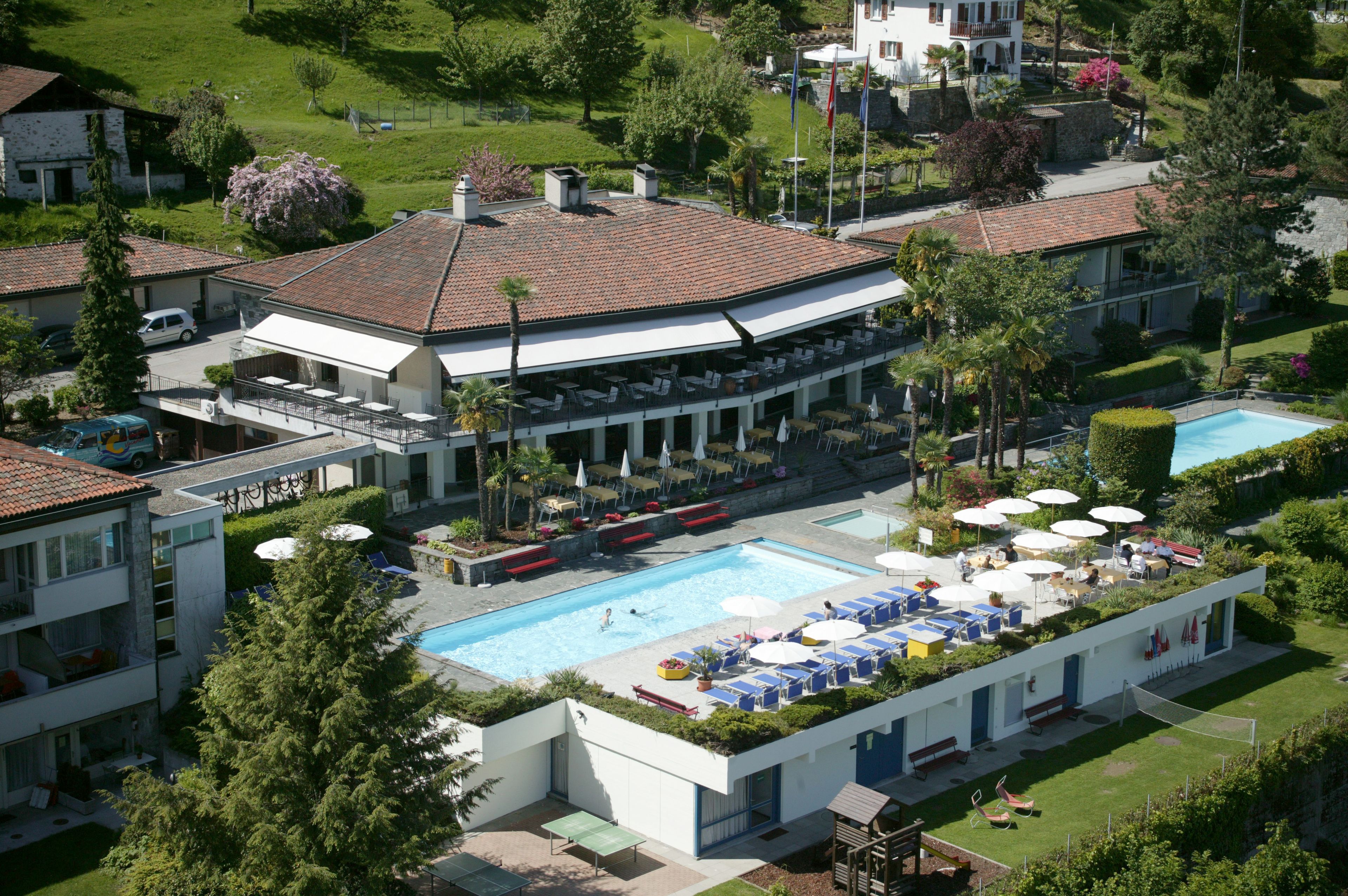 Et resort med swimmingpool, udendørs siddepladser og anlagt have.