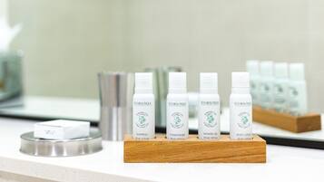 A display of eco-friendly personal care products on a wooden stand in a hotel setting.