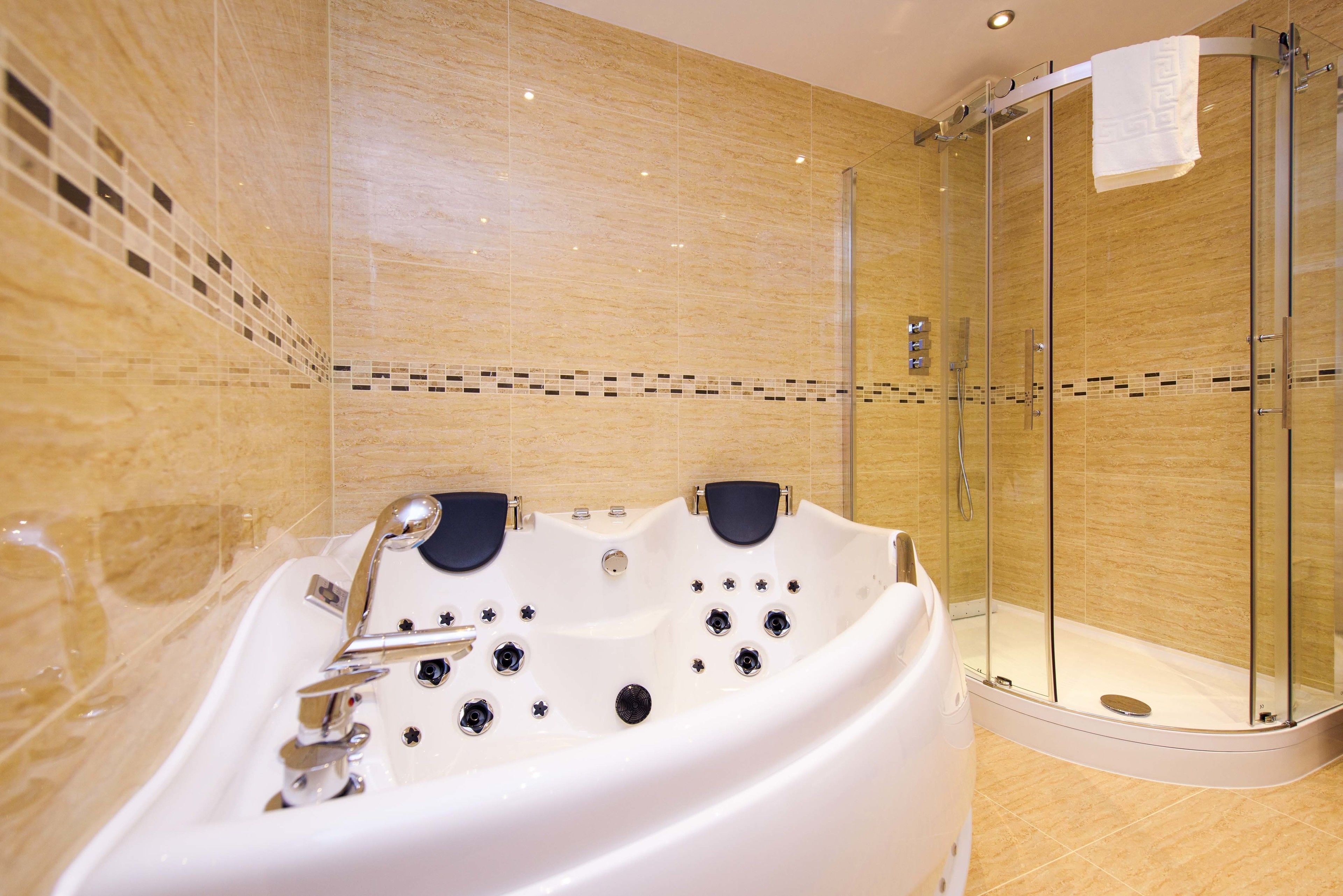 A modern bathroom with a freestanding bathtub, a glass-enclosed shower, and a tiled floor.