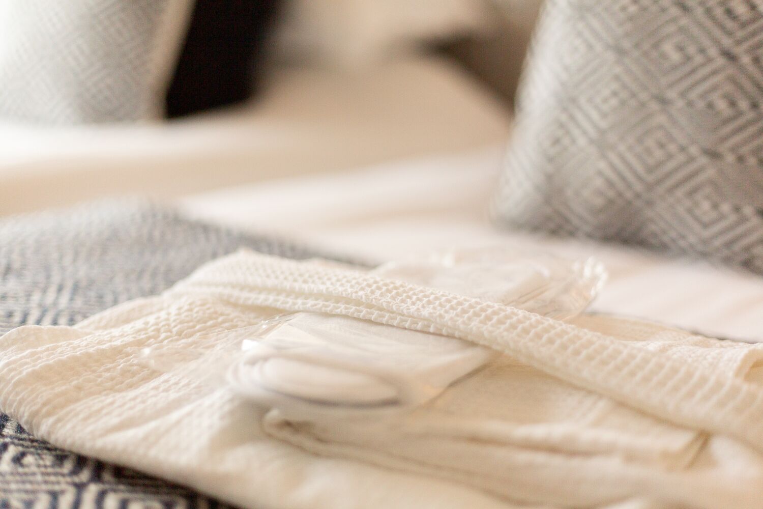 A neatly folded white blanket on a patterned couch.