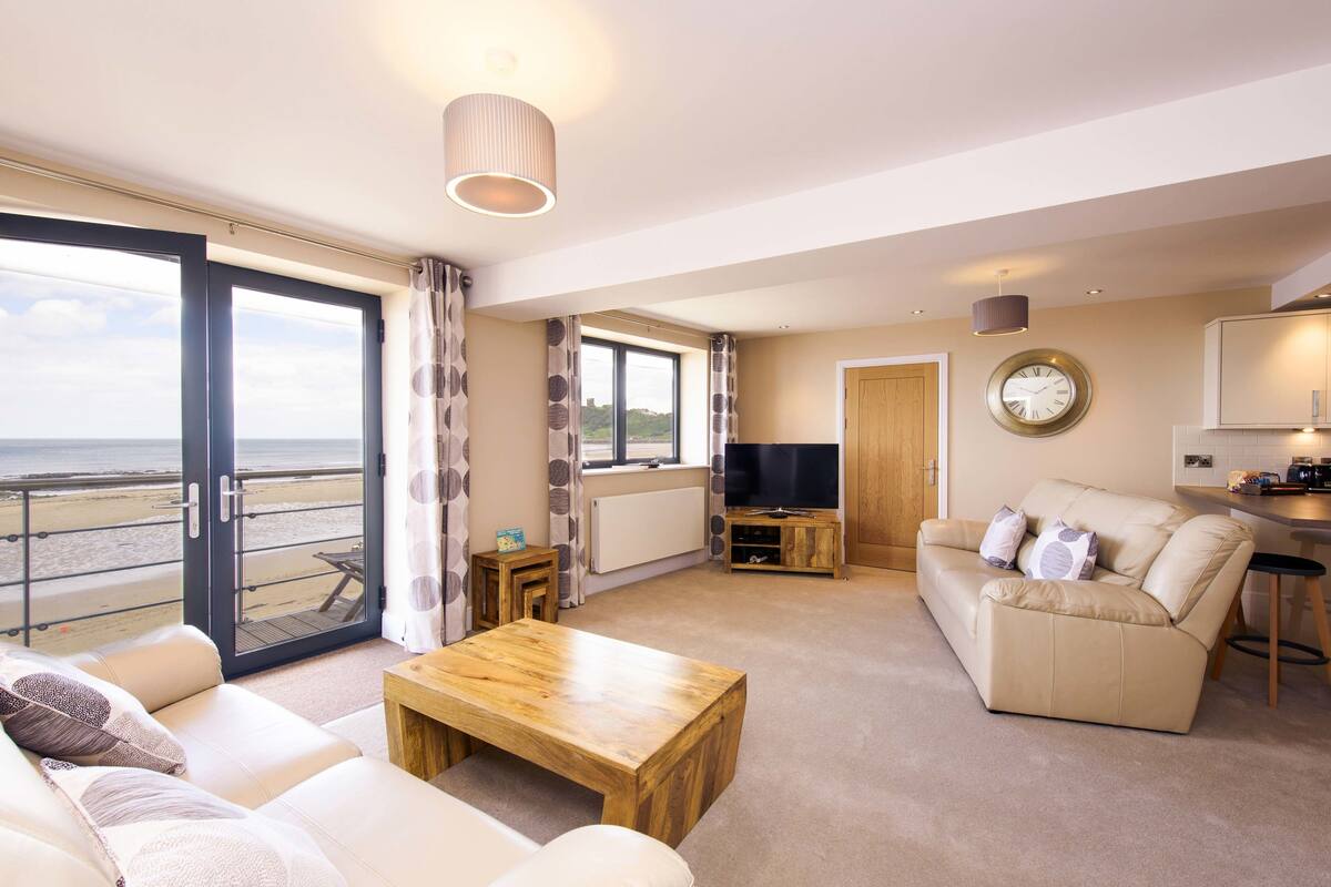 A spacious living room with a sofa, coffee table, and a TV stand.