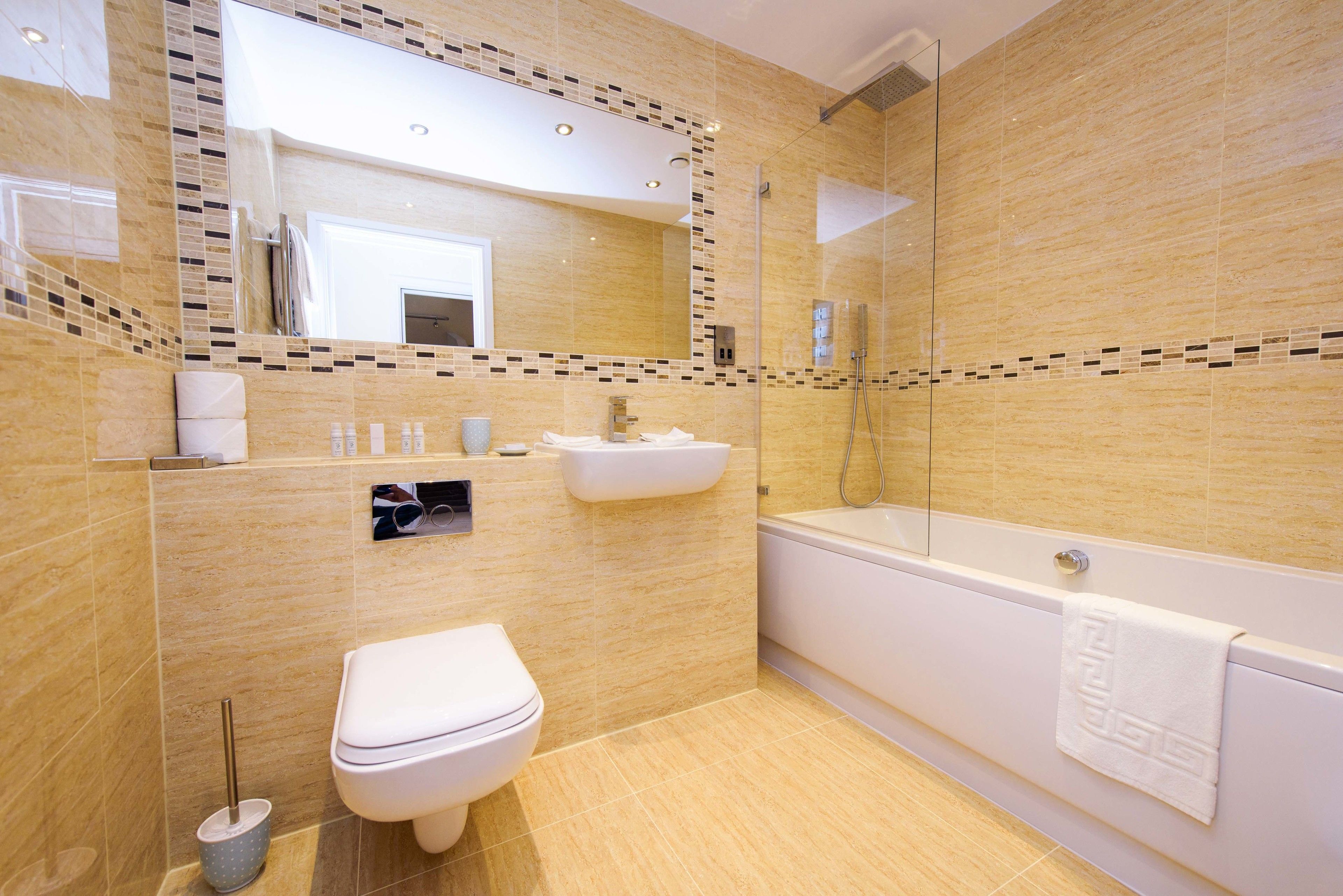 A modern bathroom with a toilet, sink, and bathtub.