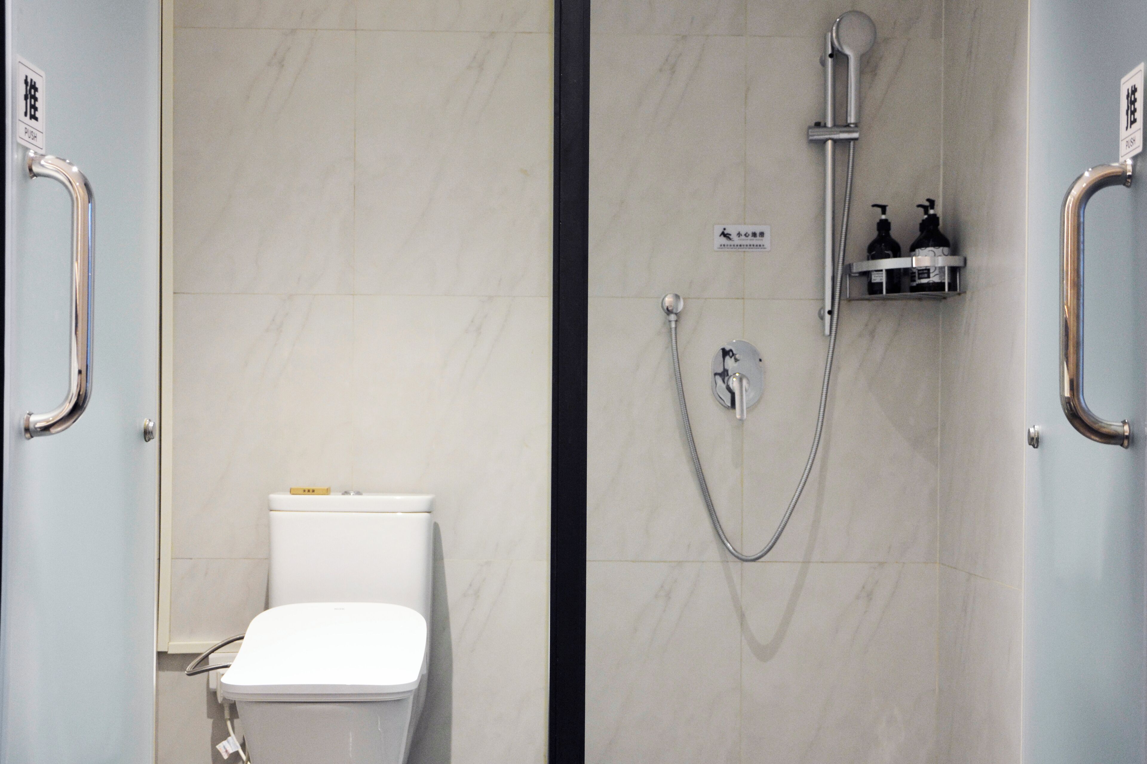 Ein Badezimmer mit Toilette, Dusche und Haltestange.