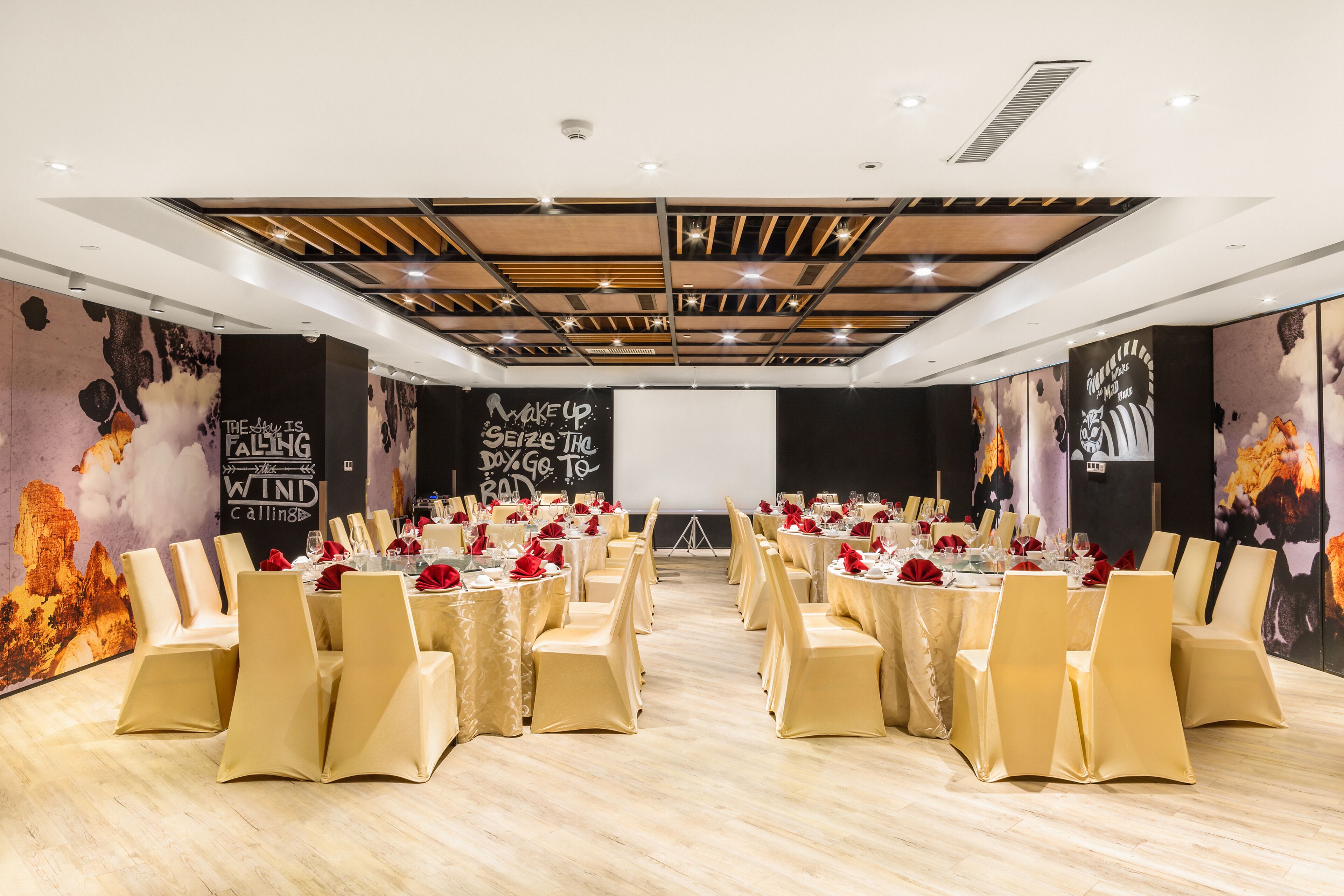 A conference room with tables set for a formal event, featuring a modern ceiling design and motivational wall art.