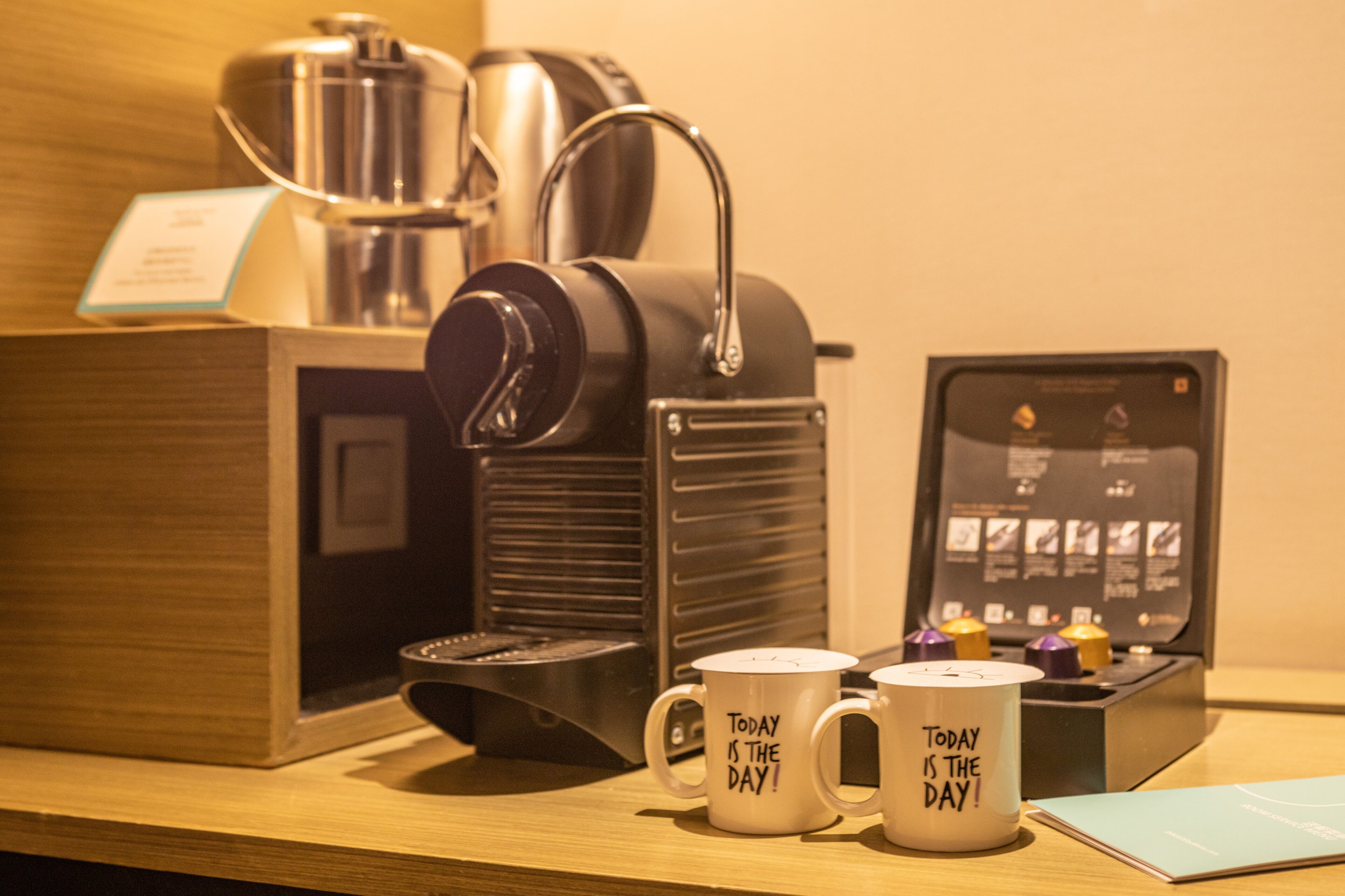 Una cafetera, dos tazas con la inscripción 