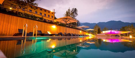 Una piscina al aire libre de temporada, sombrillas