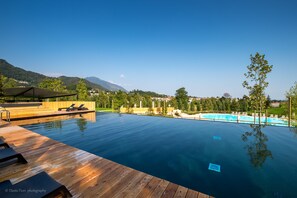 Una piscina al aire libre de temporada, sombrillas, tumbonas