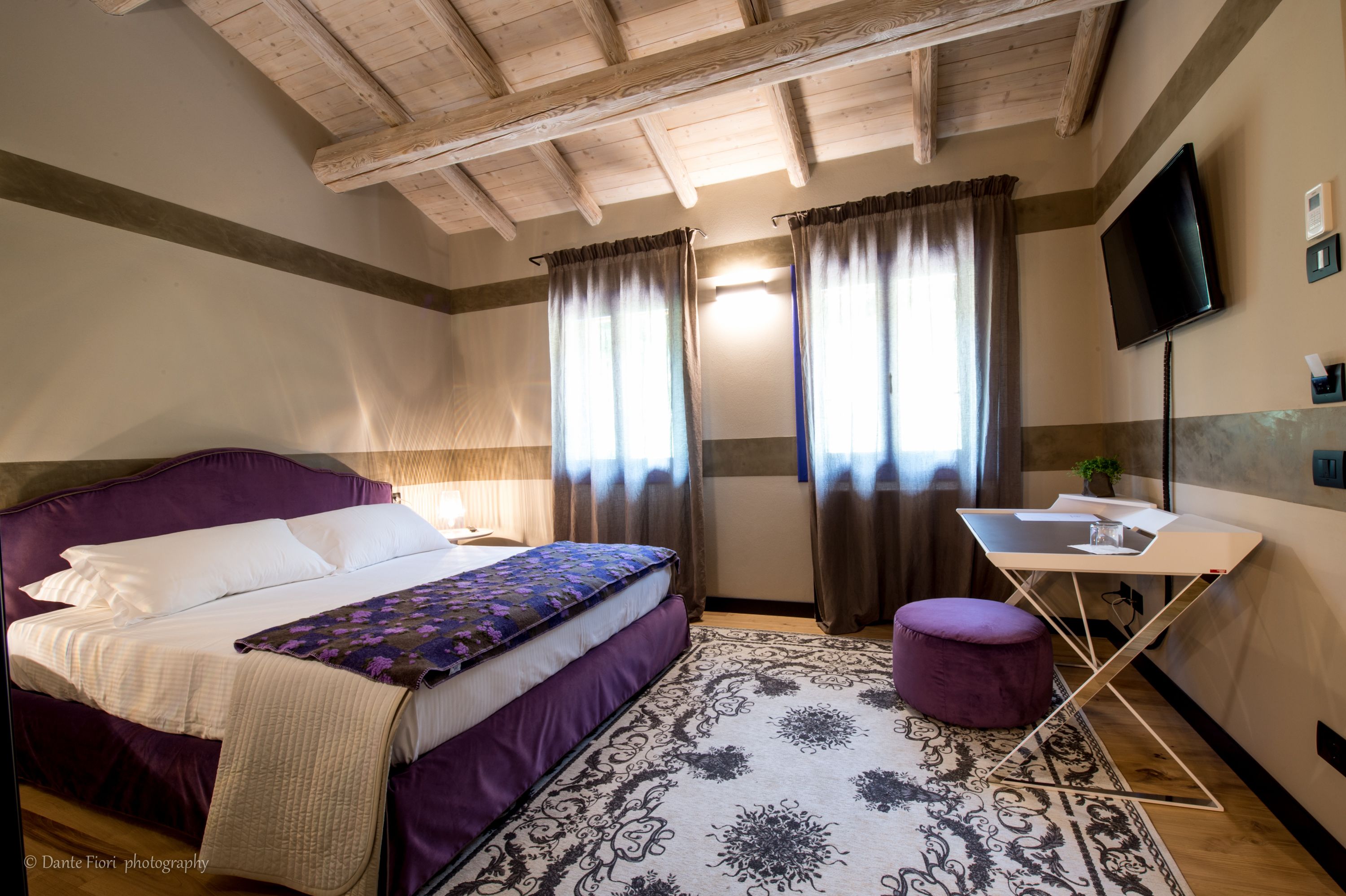 Een slaapkamer met een bed, een bureau, een stoel en een televisie.
