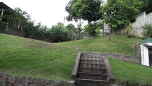 A set of stone steps leading up a grassy slope with a stone wall on one side and a building in the background. - AA Circuit bungalow (Kandy)