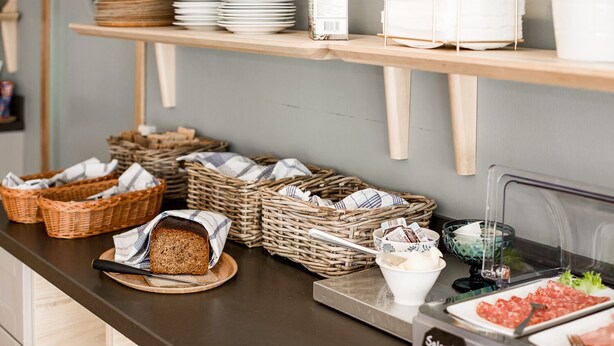 A buffet setup with various food items, baskets, and a sign indicating 'Salami'. - Duvan Hotell (Uppsala)