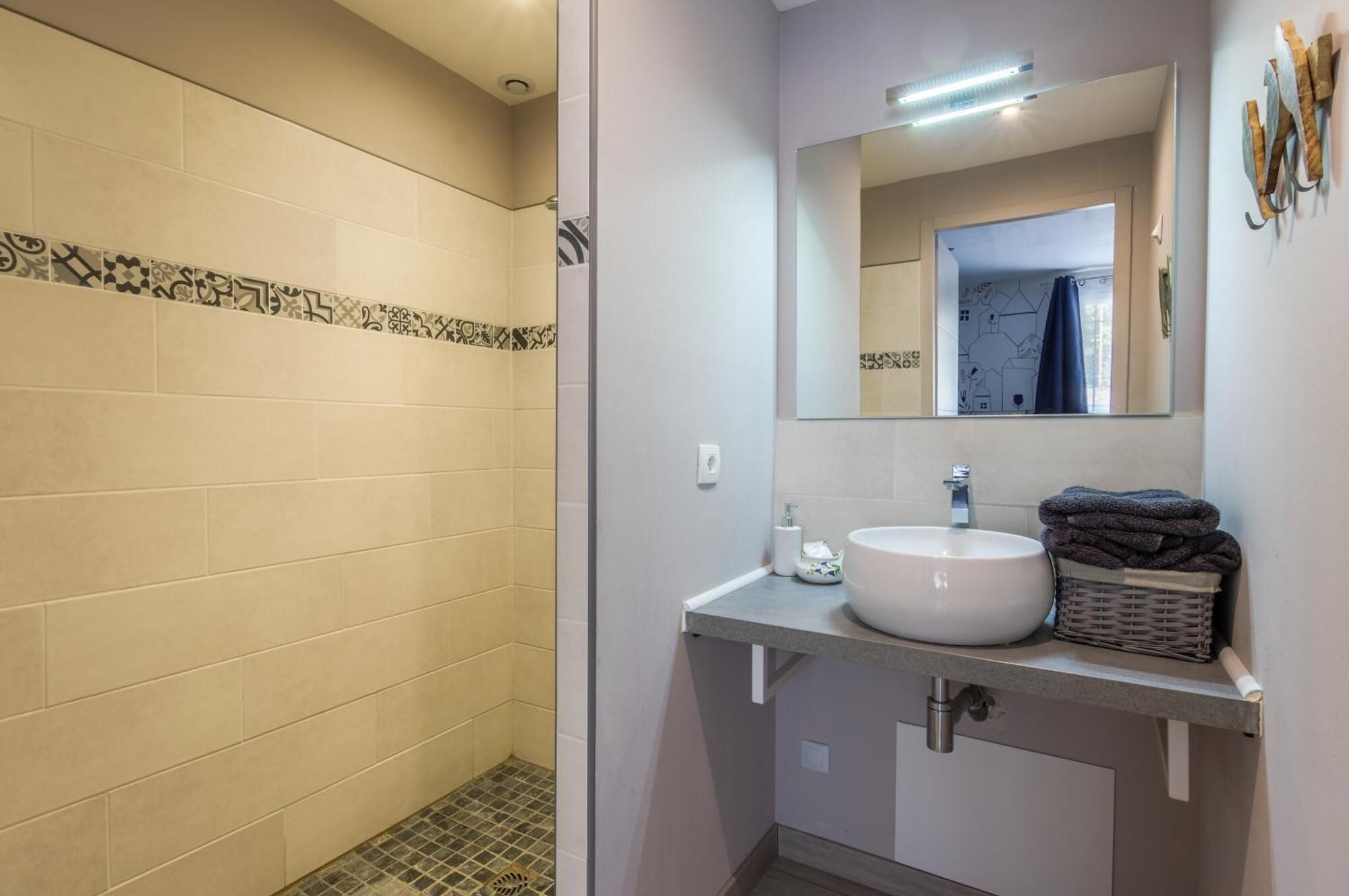 A bathroom with a shower, a sink, and a mirror.