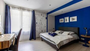 A bedroom with a bed, a desk, and a chair.