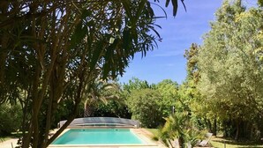 A swimming pool surrounded by lush greenery and trees. - Clos de la Colombe (Pouzols)