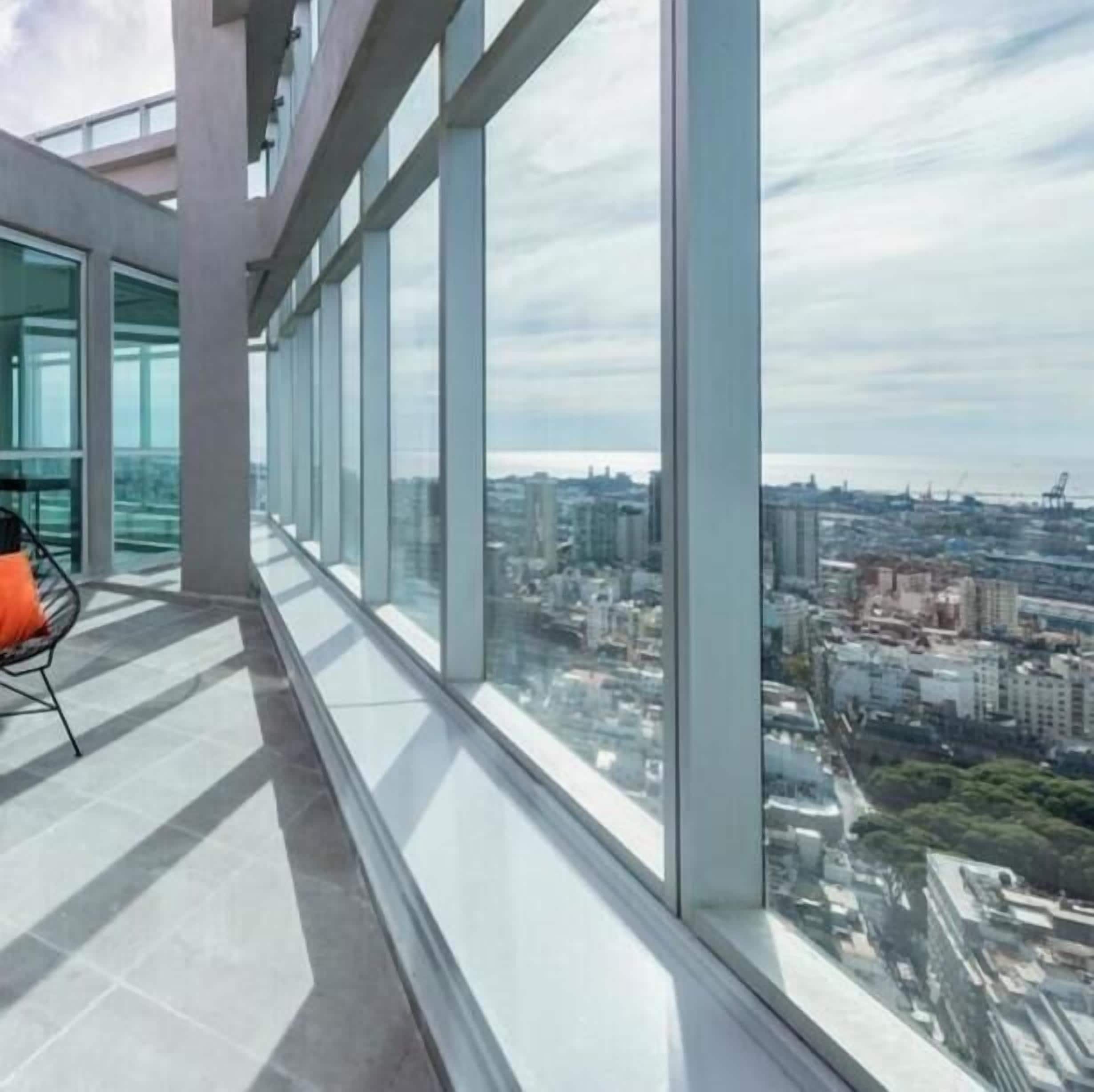Un interior moderno con un ventanal grande que da a una vista panorámica de la ciudad.