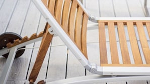 A row of wooden lounge chairs with white frames, arranged on a tiled patio. - Top Rentals Downtown (Buenos Aires)