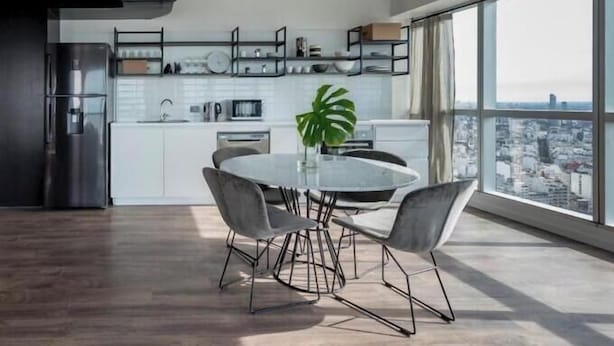 A modern kitchen with a dining area, large windows, and a city view. - Top Rentals Downtown (Buenos Aires)