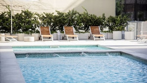 A pool area with lounge chairs and potted plants. - Top Rentals Downtown (Buenos Aires)