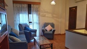 A living room with two sofas, a coffee table, and a lamp. - Apartamentos Sierra del Hacho (Montejaque)